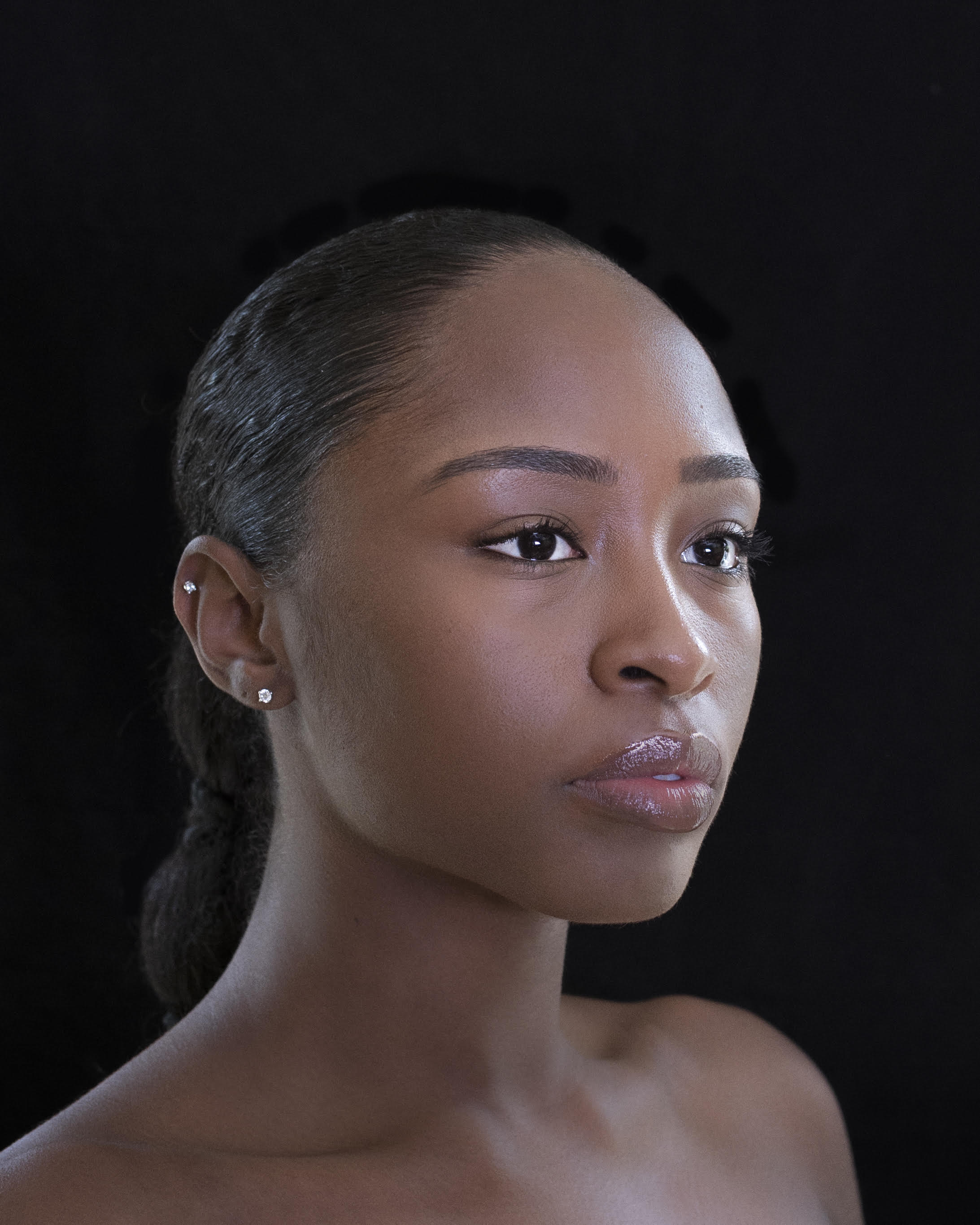 Side portrait of dancer from shoulders up with dancer looking off to side