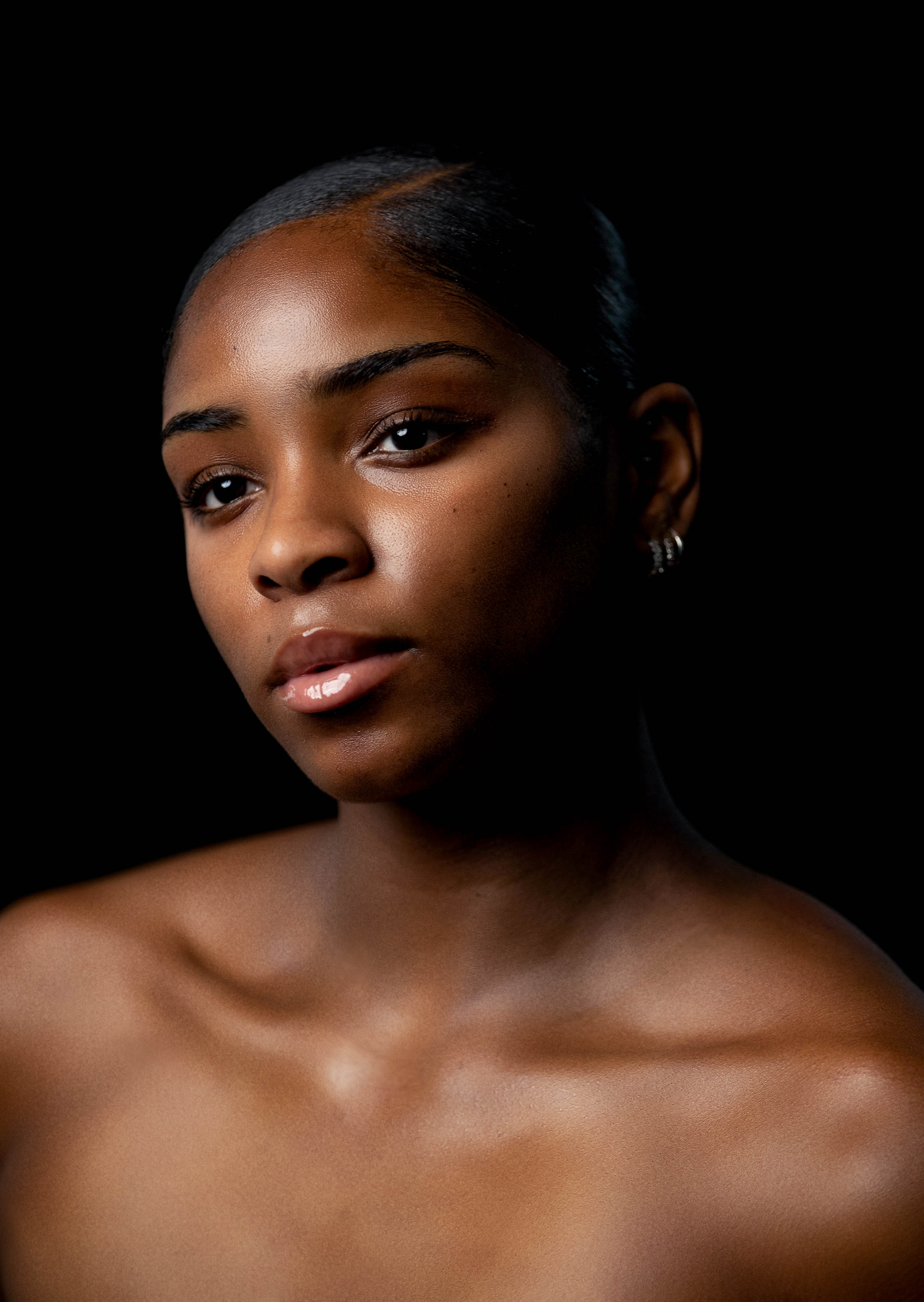 Portrait of woman from shoulders up with head tilted to right but looking directly at camera