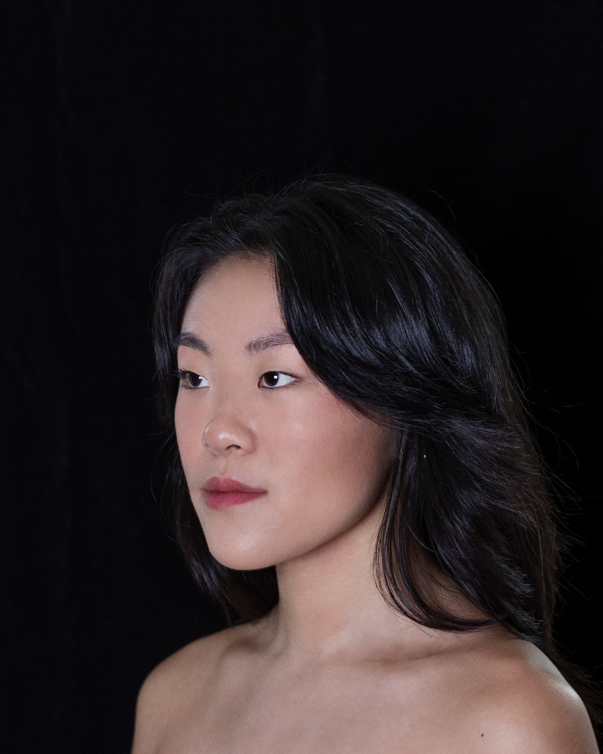 Side portrait of woman facing her right with shoulder length hair 