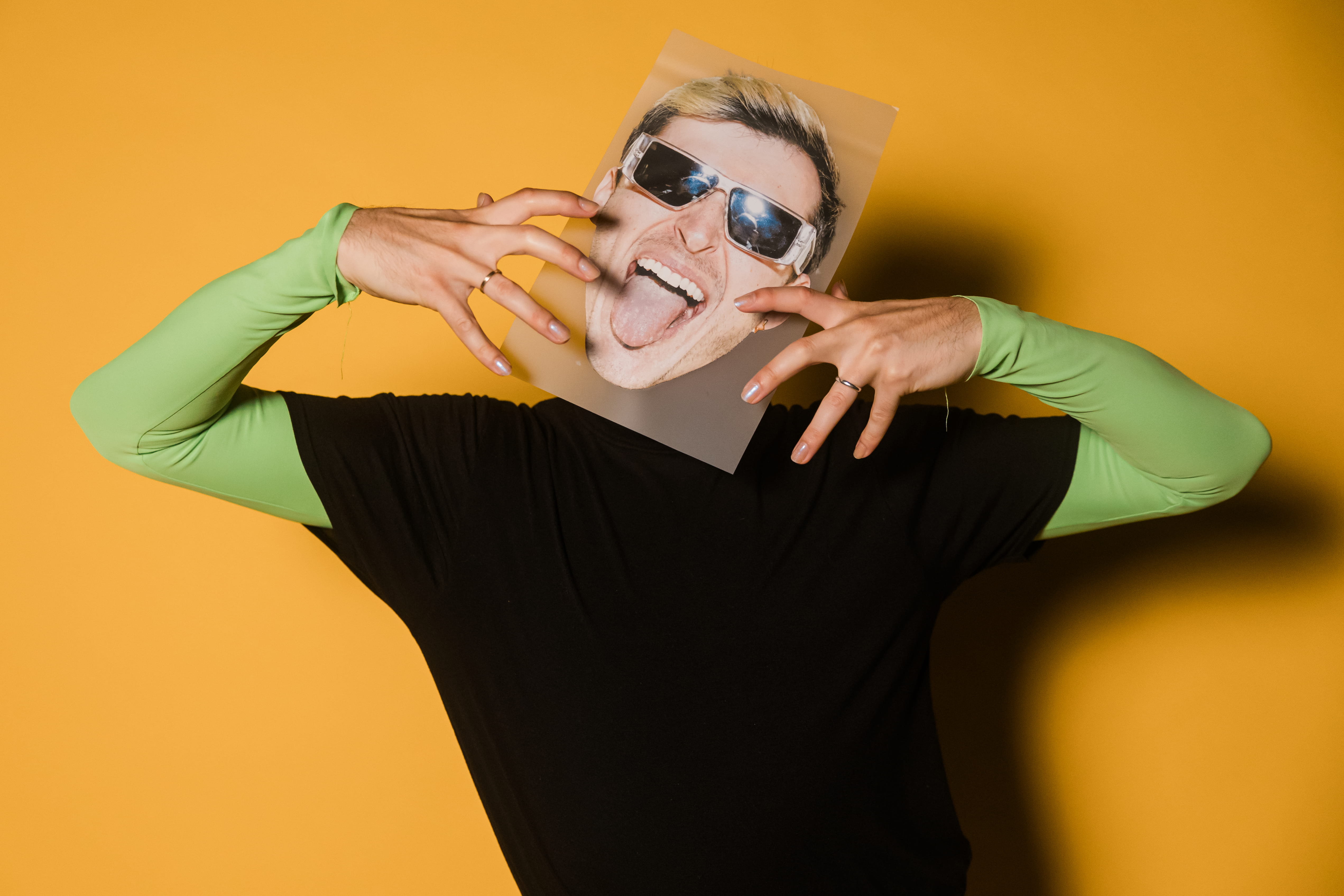 Guy holding a picture of a head on his head with a big smile