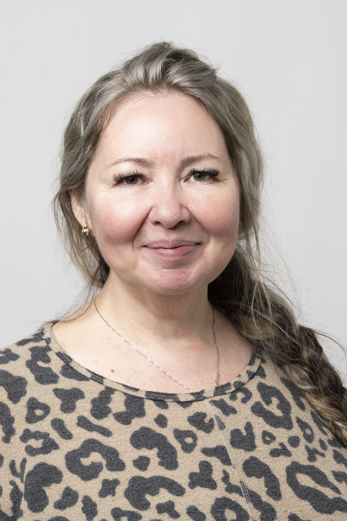 Woman wearing leopard print sweater smiling directly at camera