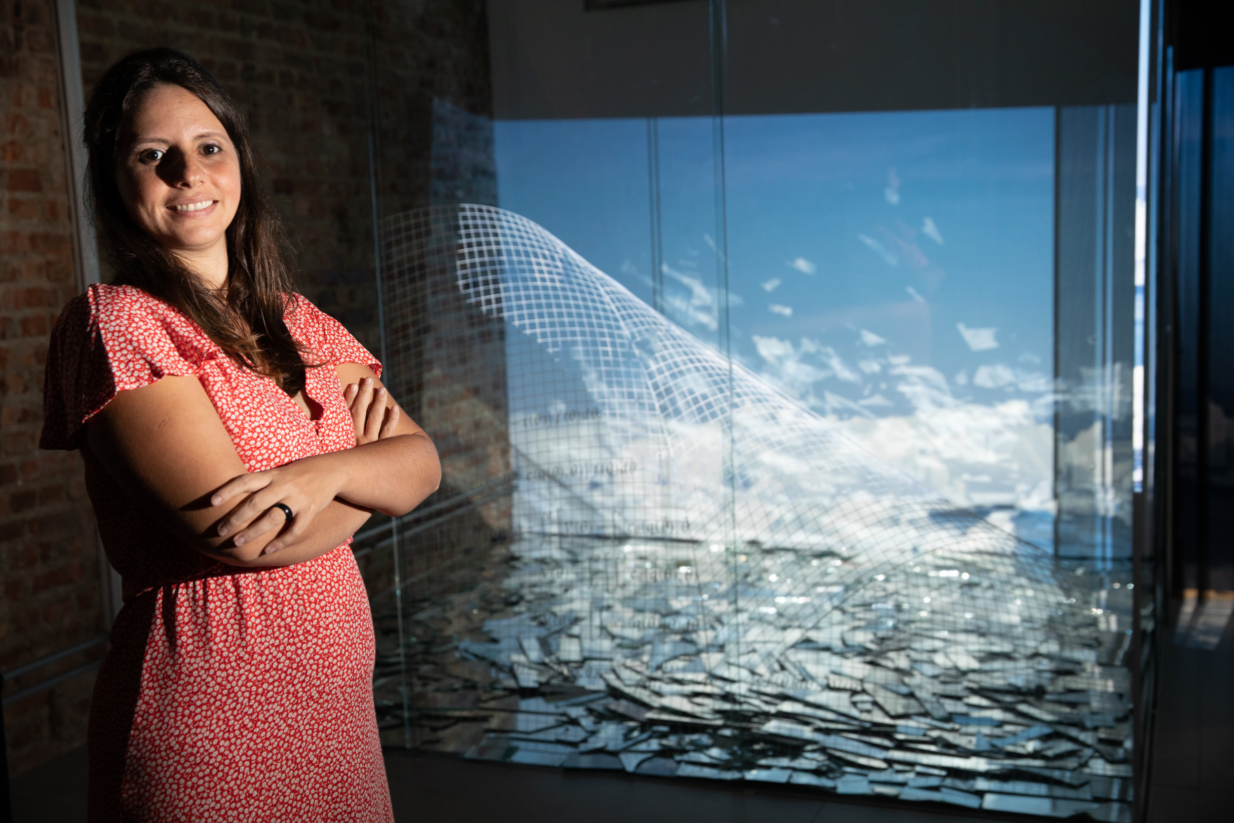 Women in a red dress standing next to an ocean like image