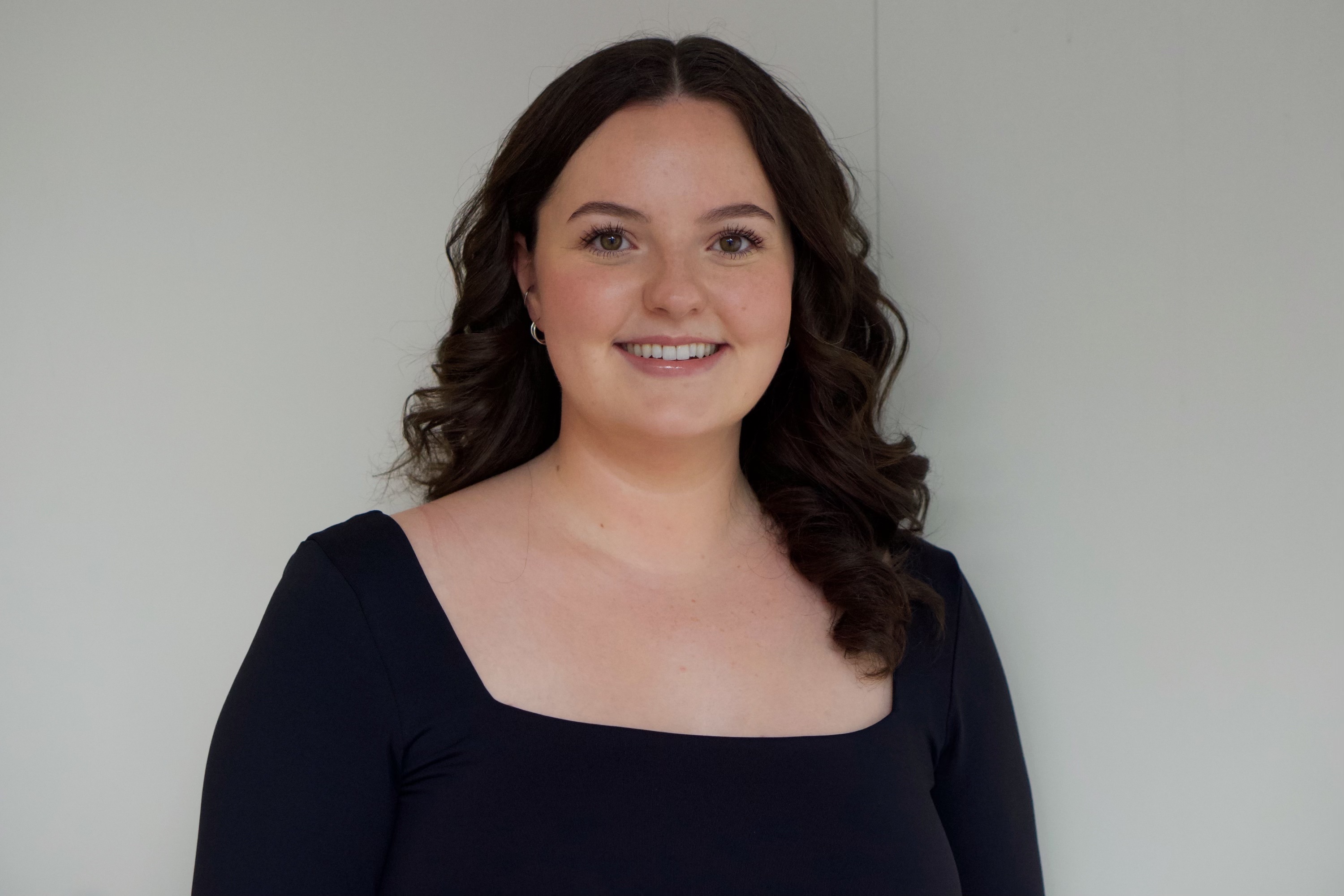 Woman smiling directly at camera with long wavy black hair