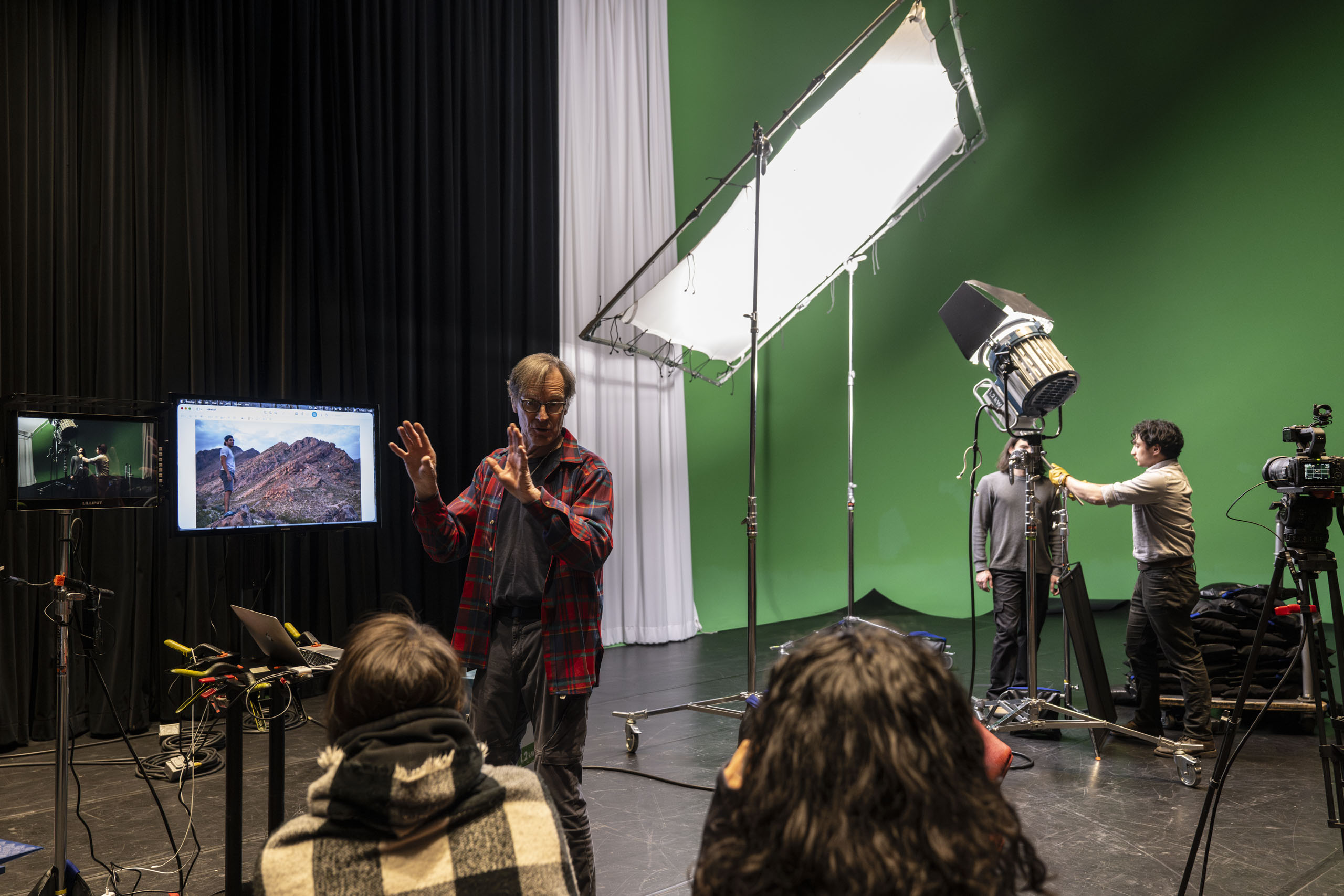 A group of students and their instructor in a green screen studio