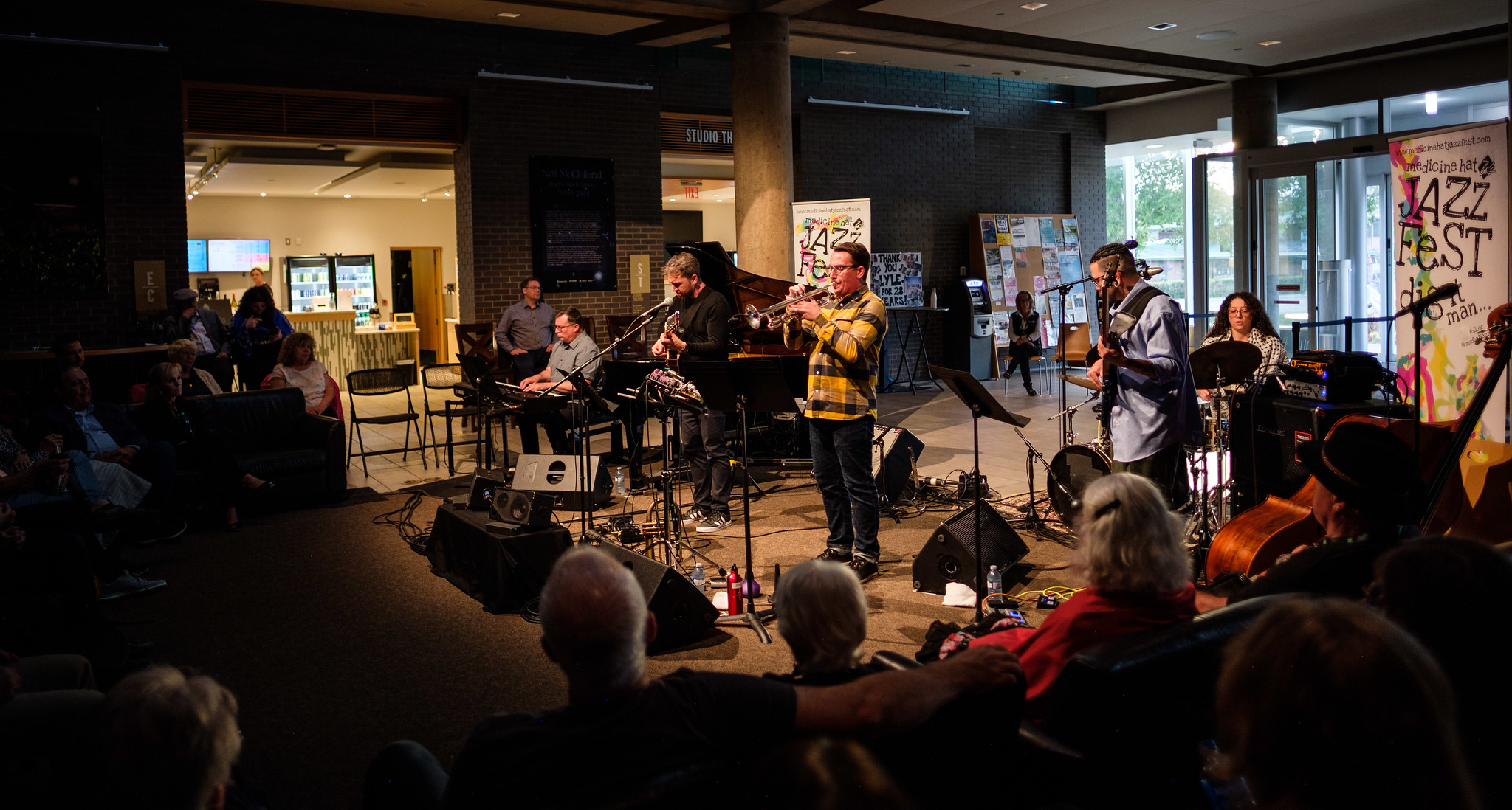 Group a musicians playing in a small room with attentive audience