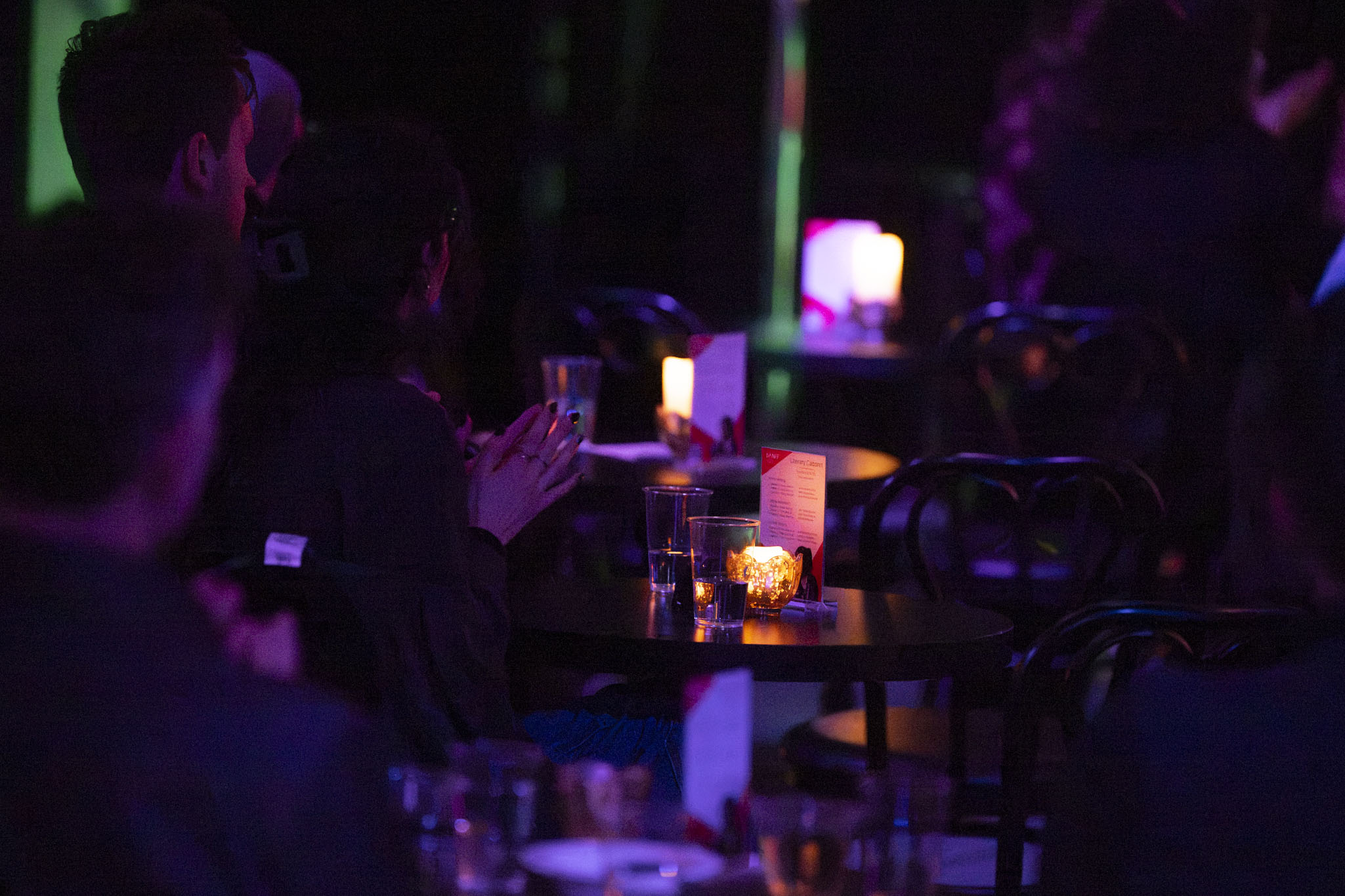 People sitting at tables clapping hands at event in CLVB'33 