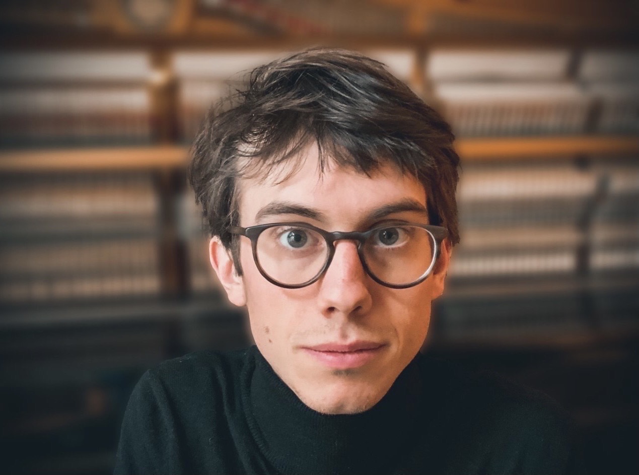 Man wearing glasses and turtle neck shirt looking at camera
