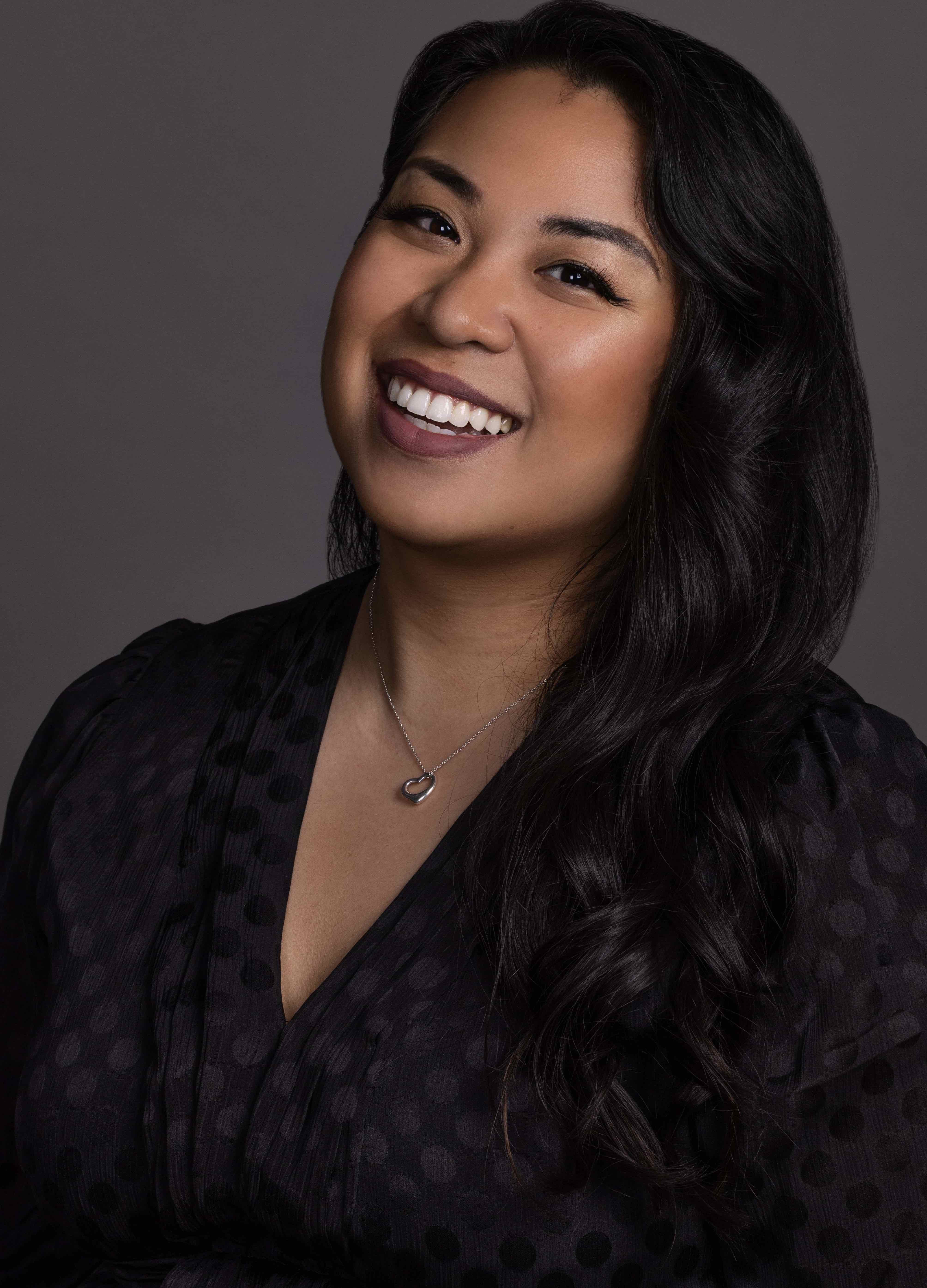 Woman in v neck blouse smiling broadly at camera