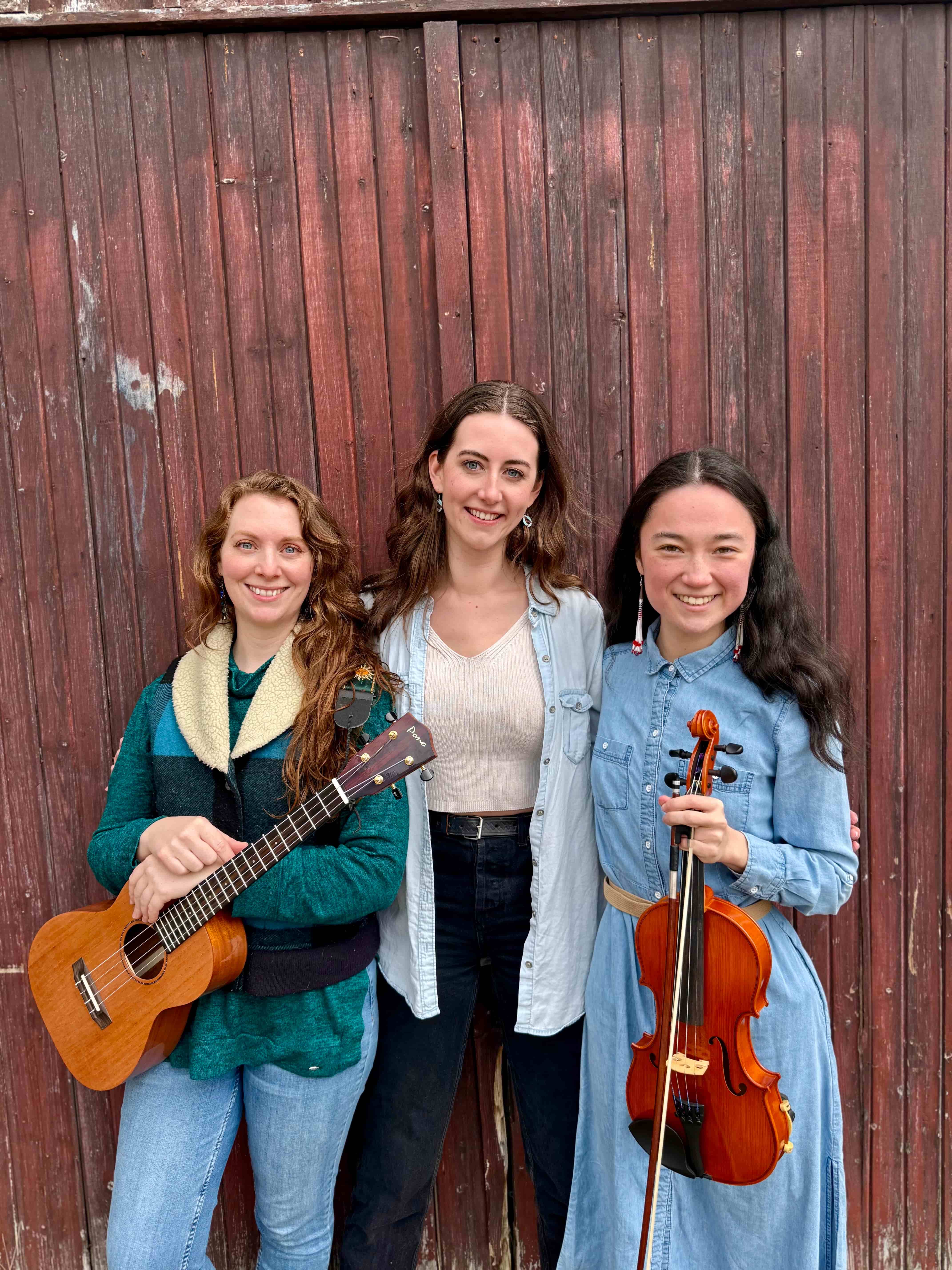three young women left woman holding a guitar, right woman a violon.
