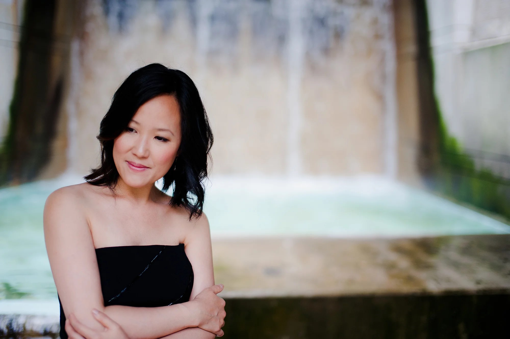 A woman in a black dress poses for a picture