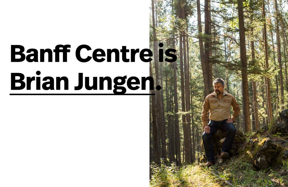 Brian Jungen, visual artist sits in a forest on a sunny day. 