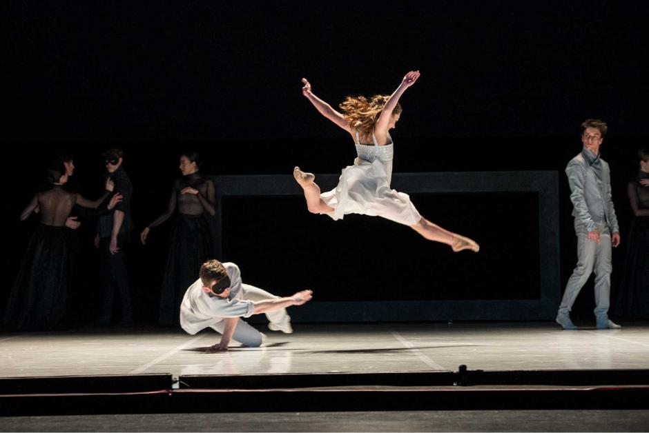 Romeo + Juliet ballet performance on a black stage. Two dancers in the forefront with a number in the background.