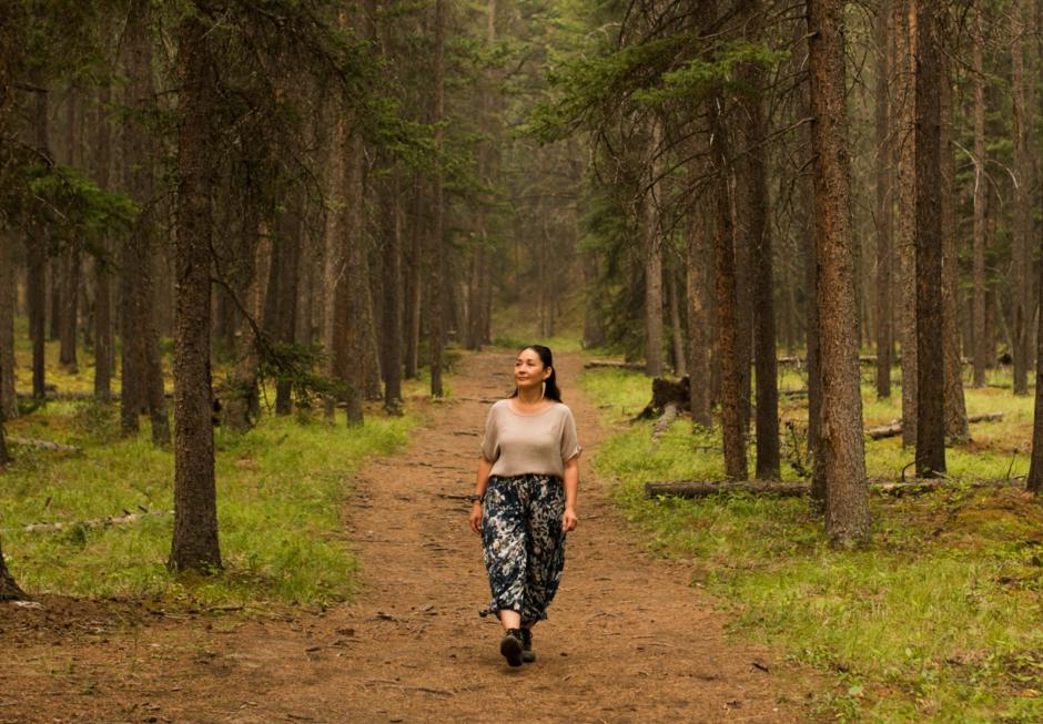 Artist Reneltta Arluk walking through the forest on a rainy day. 