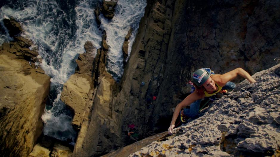 A female climber hanging over a cliff
