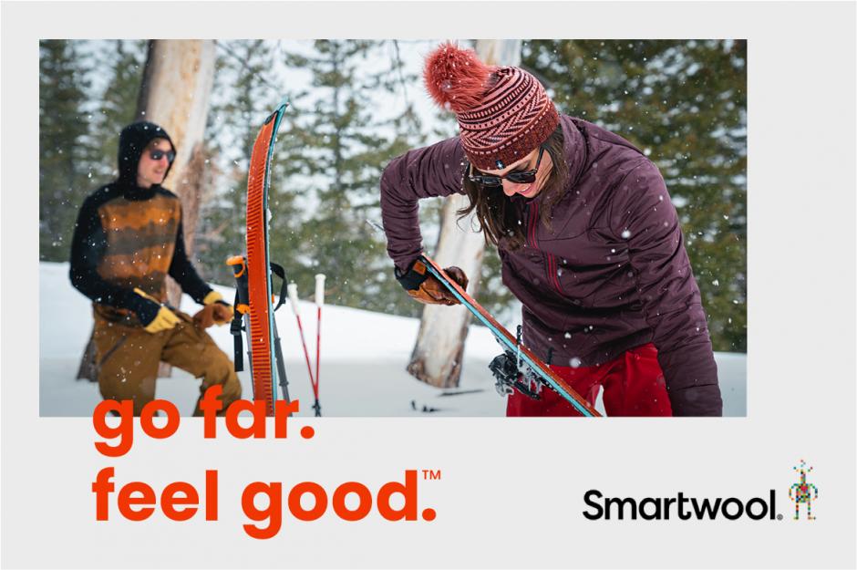 Skiers preparing their skis in the snow. 