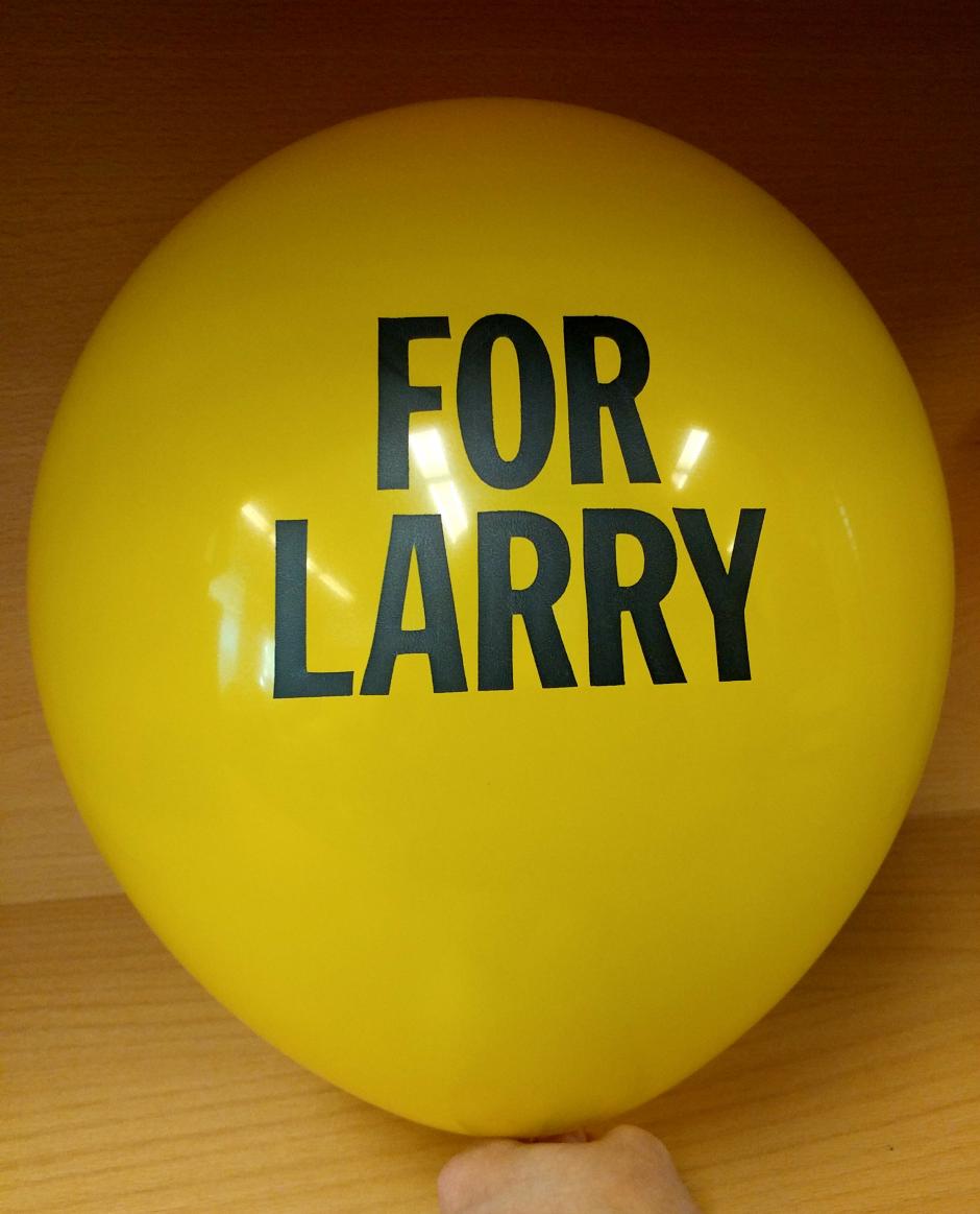 A yellow balloon inflated with the text, "For Larry," printed on it. 