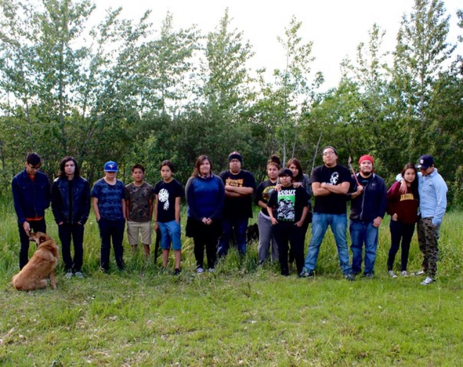 14 members of the Nakoda AV Club stand in a line facing the camera