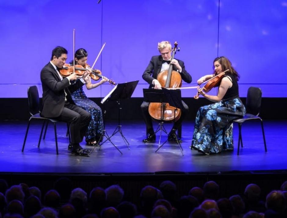 Viano Quartet 2019. Photo by Jessica Wittman. String Quartet playing on a blue lit stage
