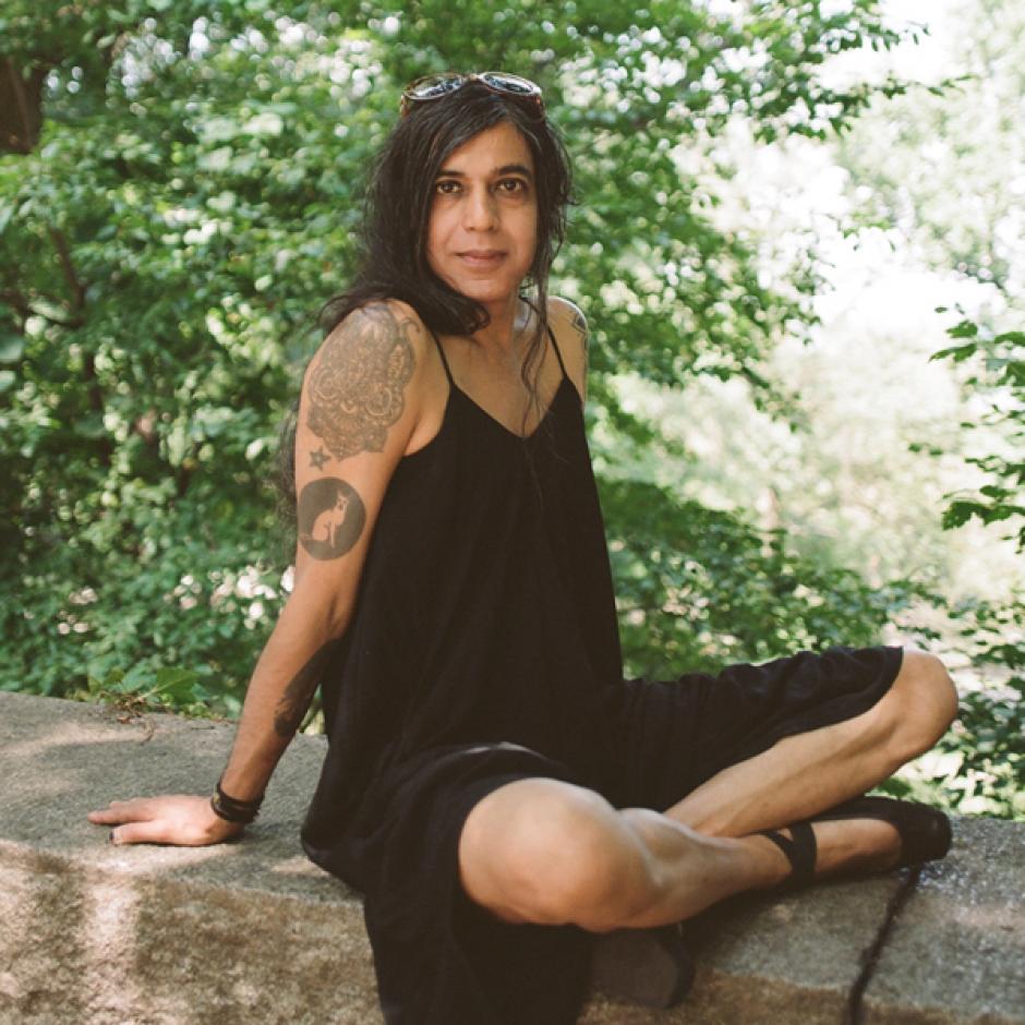 Photo of program faculty, Bishakh Som sitting cross legged outdoors