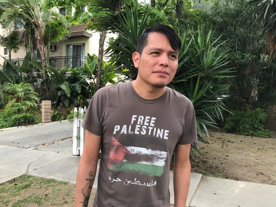 Photo of program faculty, Orlando White, outdoors, looking off-camera, wearing 'Free Palestine' t-shirt