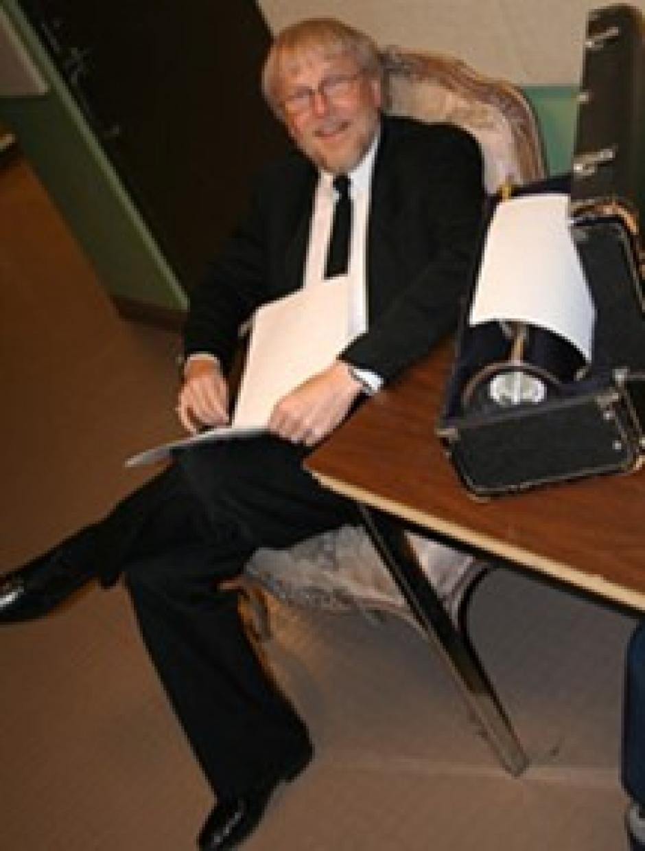 Ed Harkins sits in a suit with papers in his hands