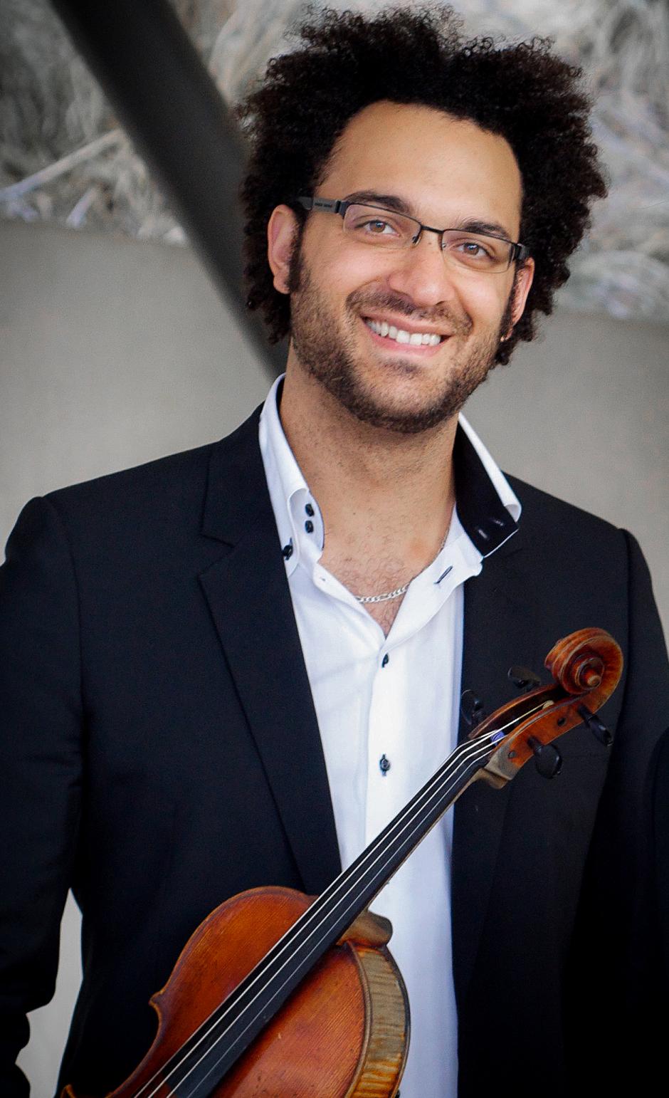 Man with glasses smiles while holding a viola