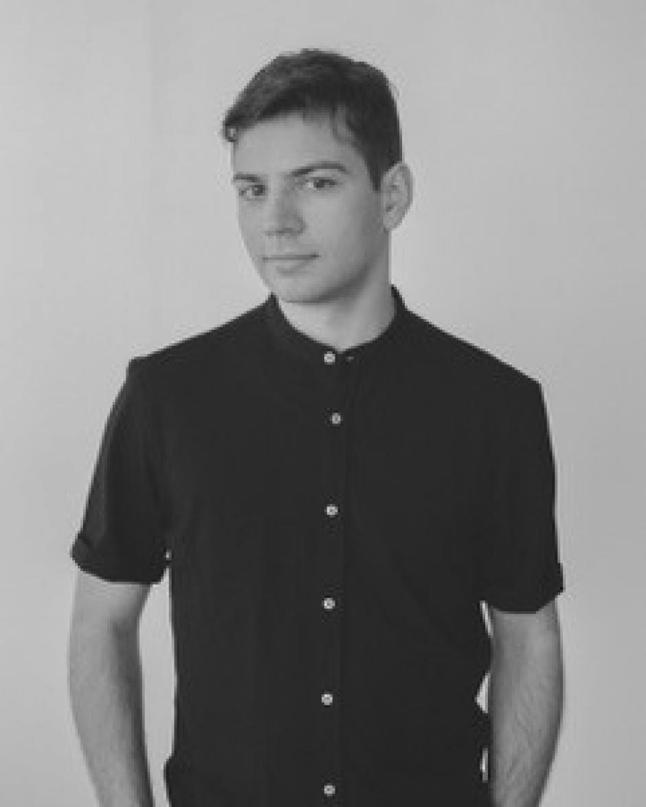 Black and white photo of Juan Salvador. He is wearing a dark shirt. 