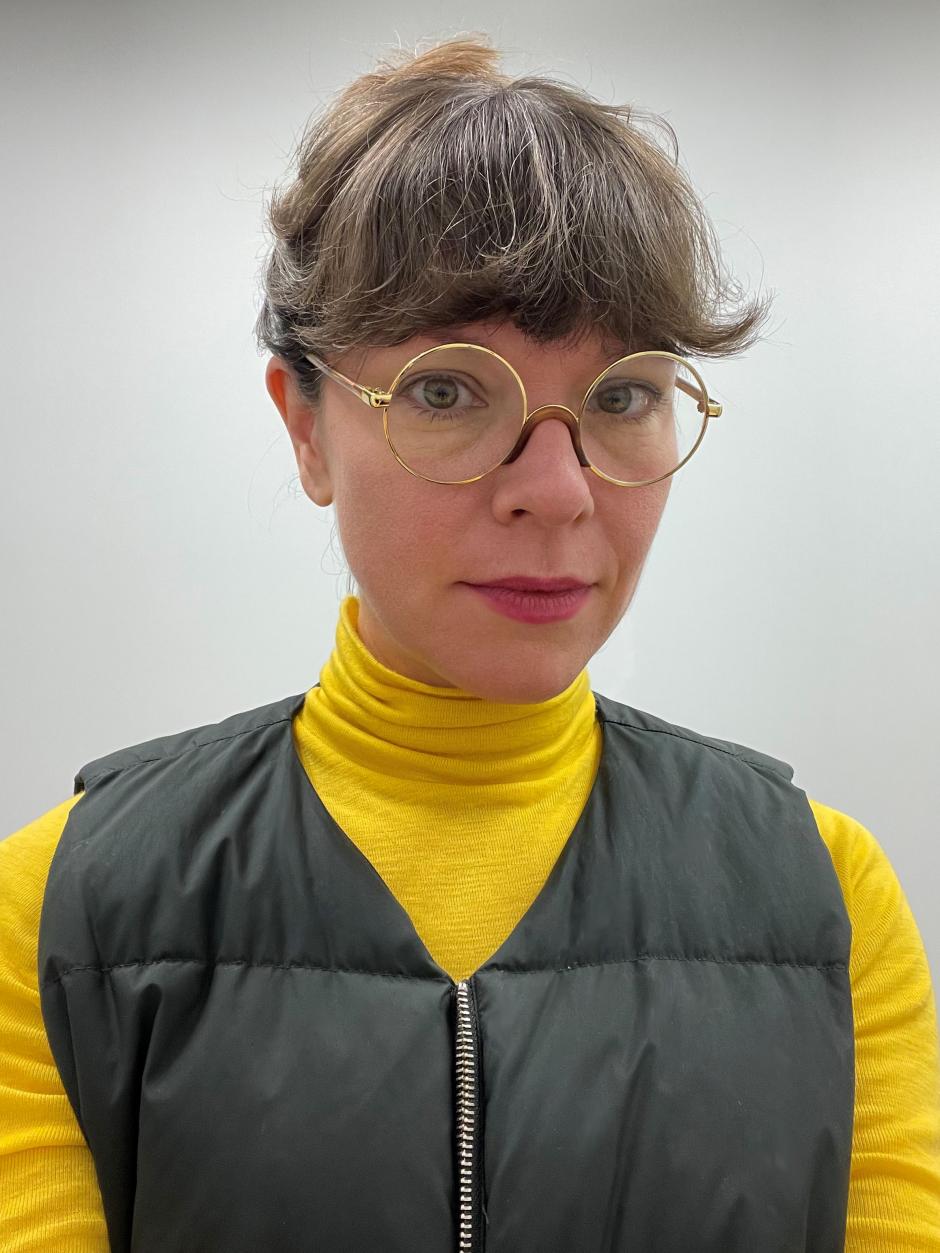 Photo of program faculty, Elisabeth Belliveau, in round glasses and a bright yellow top