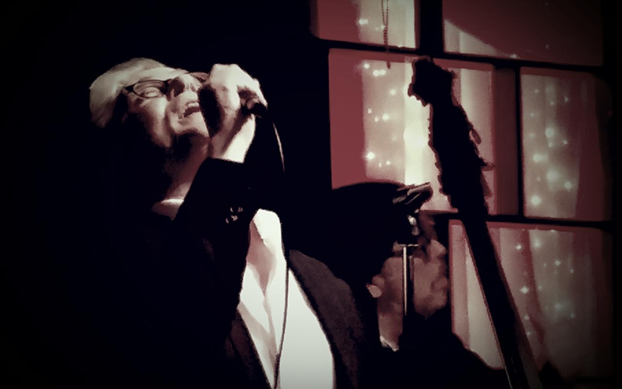John Alcorn on the stage singing