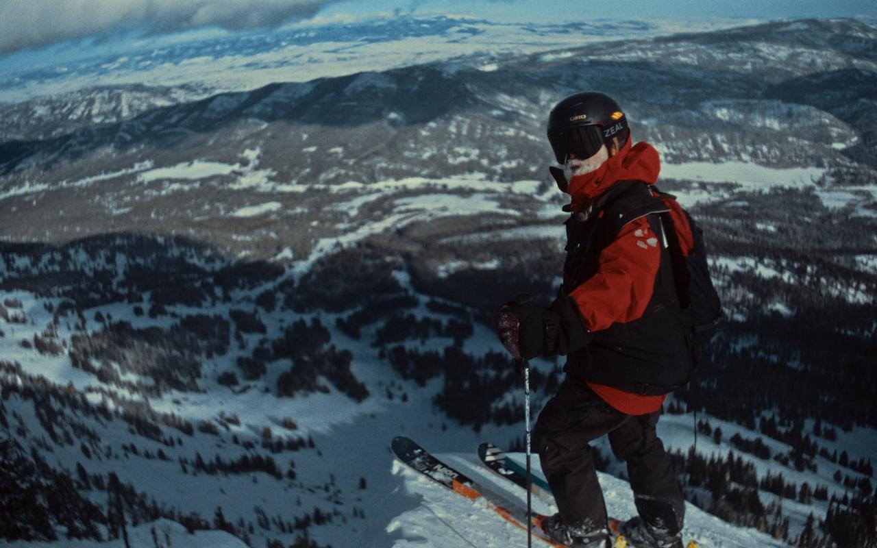 Man standing on a top of a mountain on skis 