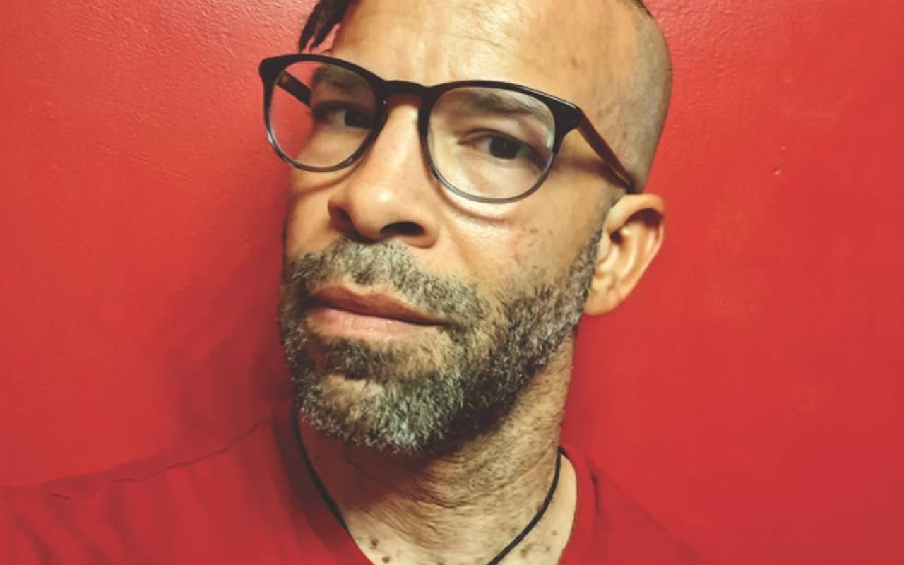 Douglas Kearney in glasses wearing a red shirt.