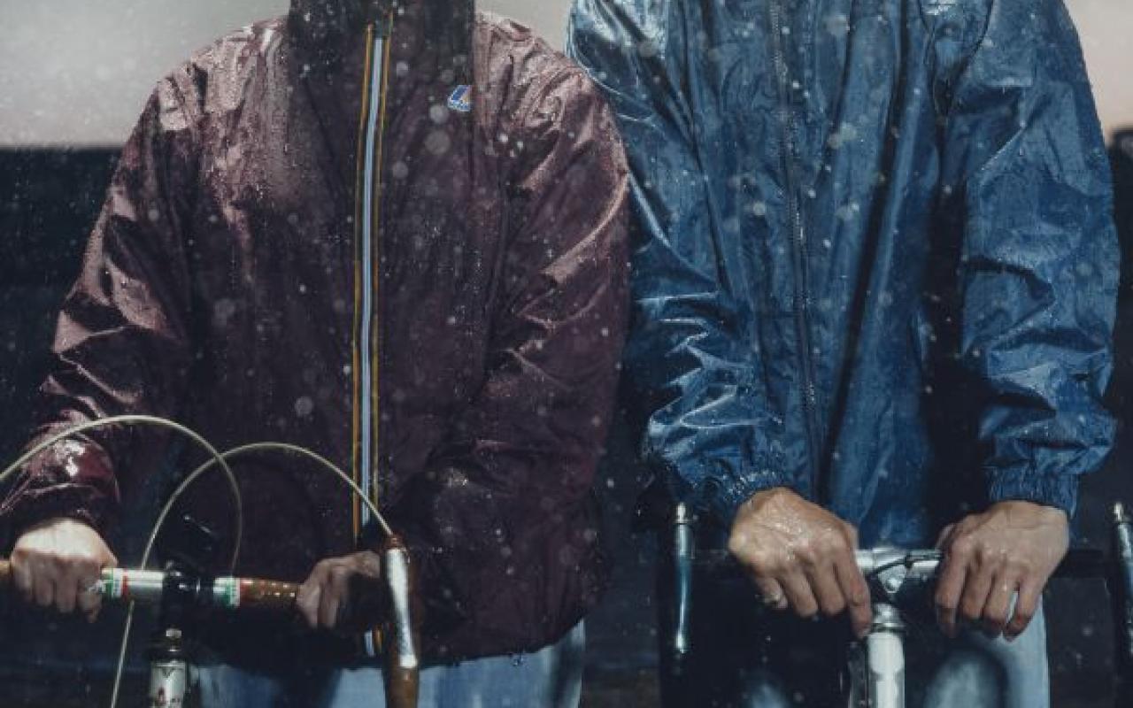 Members of the band Ghostkeeper standing with bikes in the rain.