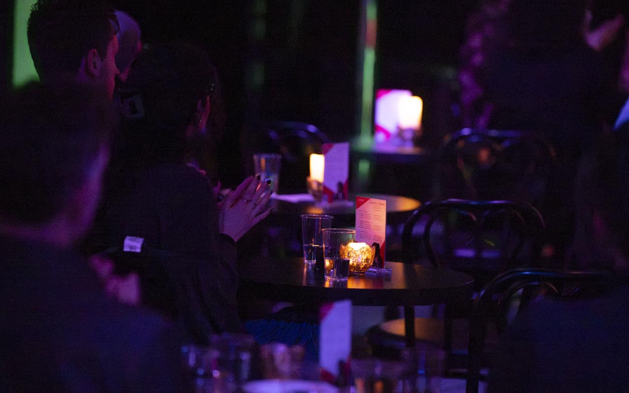 People sitting at tables clapping hands at event in CLVB'33 