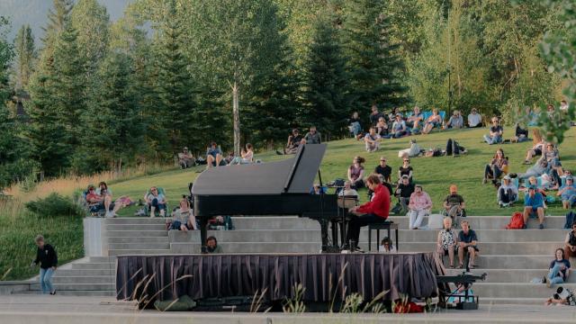 Person playing the piano while others listen