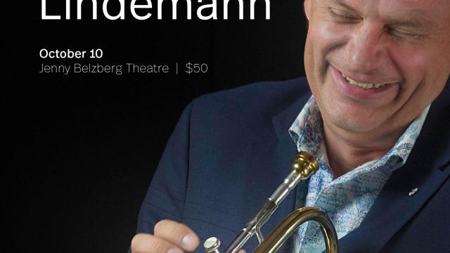 Jens Lindemann portrait laughing and holding brass in his hands 