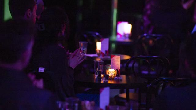 People sitting at tables clapping hands at event in CLVB'33 