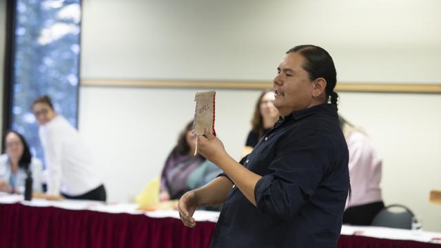 An instructor is addressing a room full of participants