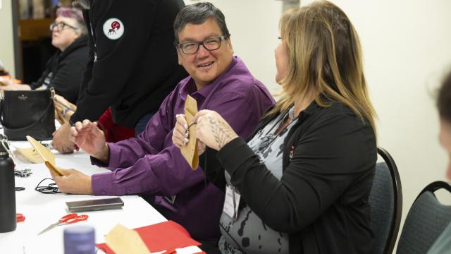 A man in a purple shirt is having a conversation with a woman in a black sweater