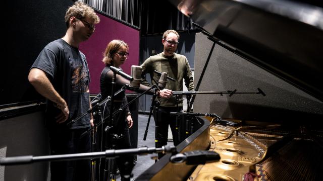 Two audio engineer participants receive instruction from faculty
