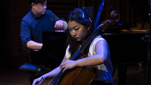 A man is playing piano and a woman is playing cello