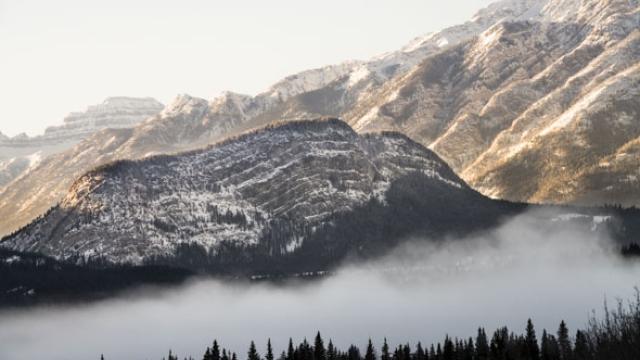 snowy mountain with mist in foreground