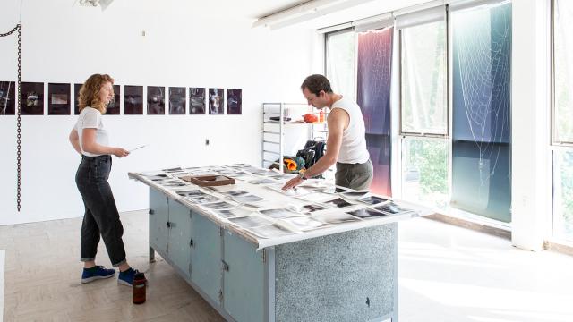 Artists collaborating in a bright sunny studio.