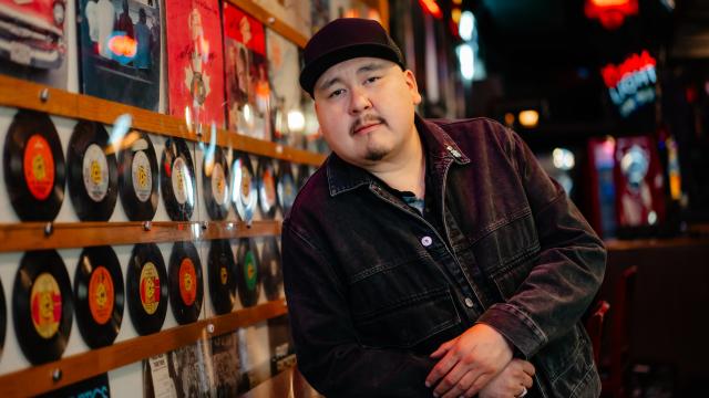 Man wearing black hat and jacket standing in a disk shop 