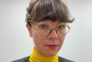 Photo of program faculty, Elisabeth Belliveau, in round glasses and a bright yellow top