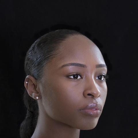 Side portrait of dancer from shoulders up with dancer looking off to side