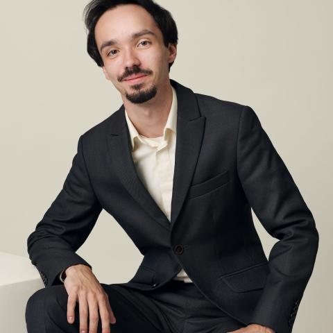 Man with black suit looking directly at the camera