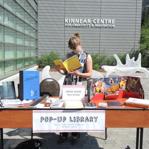 Library staff member reading a book at the pop-up library