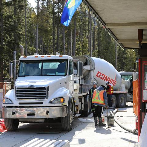 Construction crews stand near a concrete truck outside the renovated theatre.