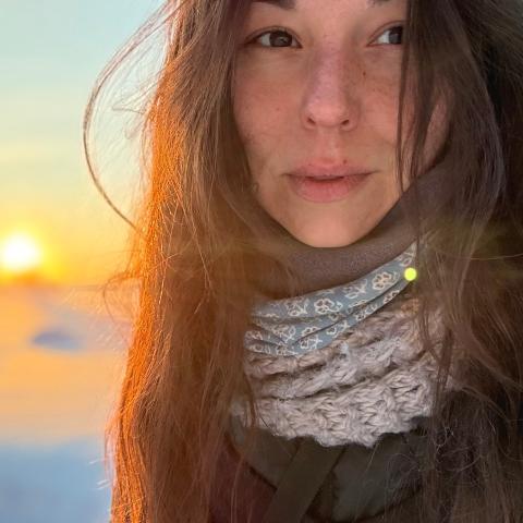 Women with long hair on the snow ground by sunrise