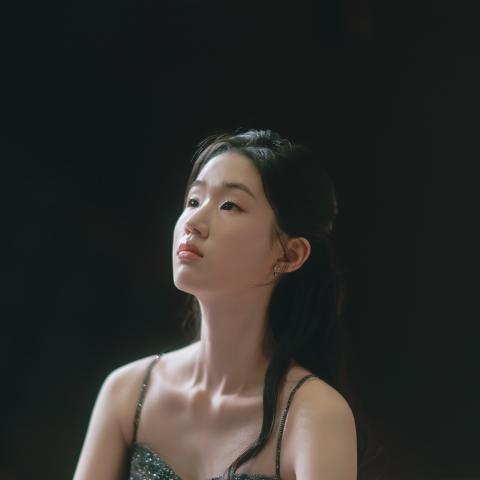 Woman sitting at the piano looking off camera